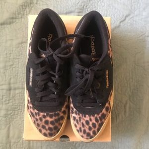 Black and gold leopard print low top converse.